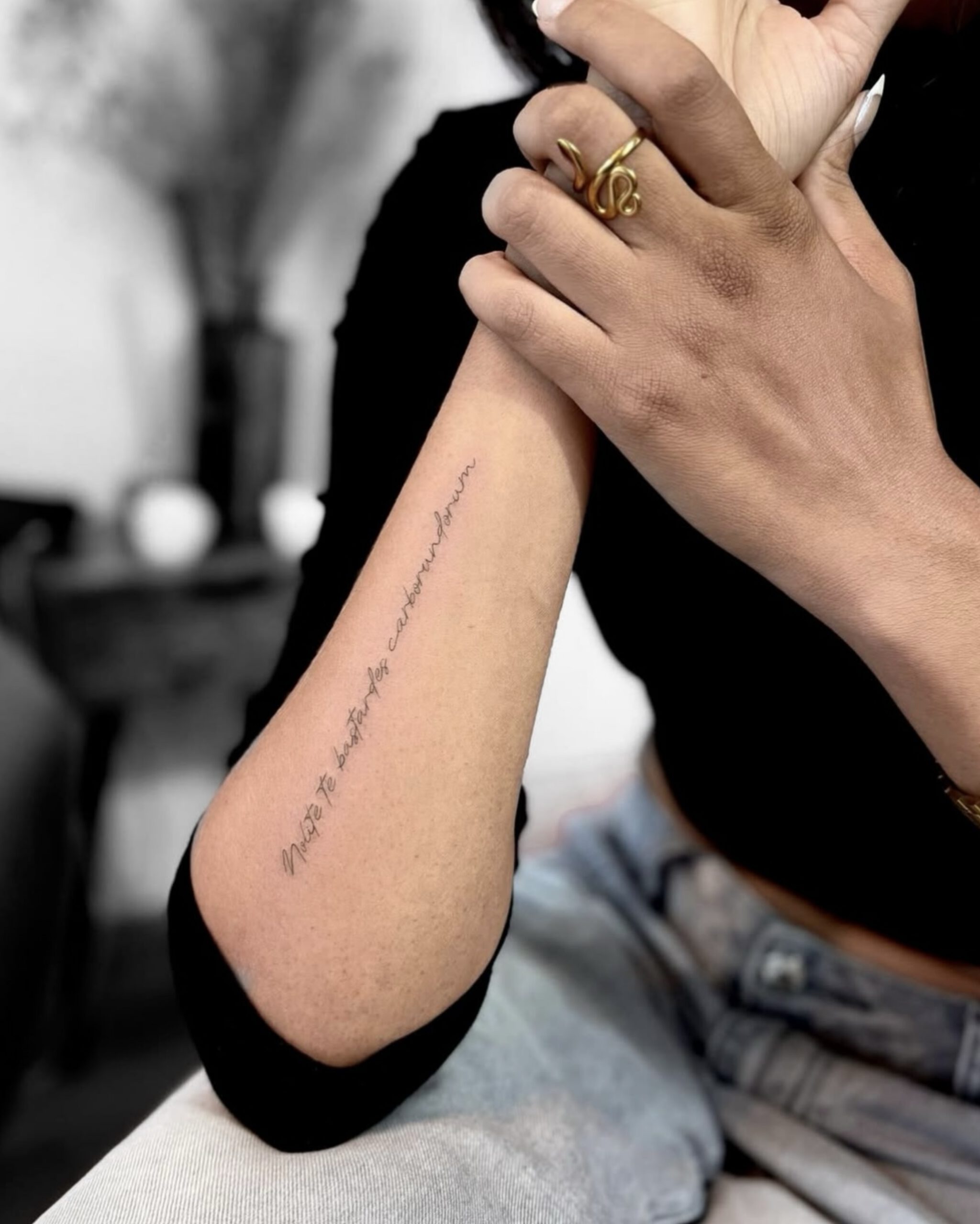 Fine Line Schriftzug-Tattoo am Unterarm in Berlin-Schöneberg