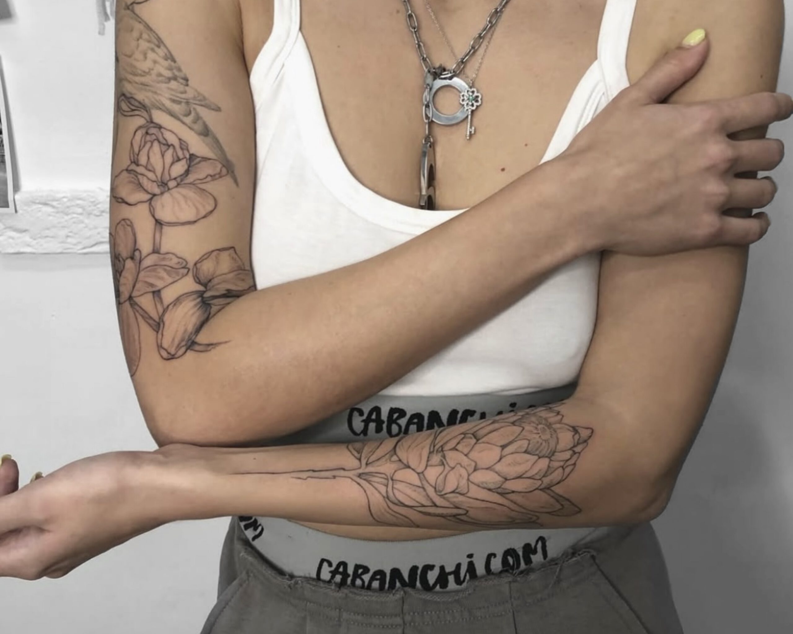 Großes florales Fine Line Tattoo mit Blumen und Blättern am Arm in Berlin-Charlottenburg
