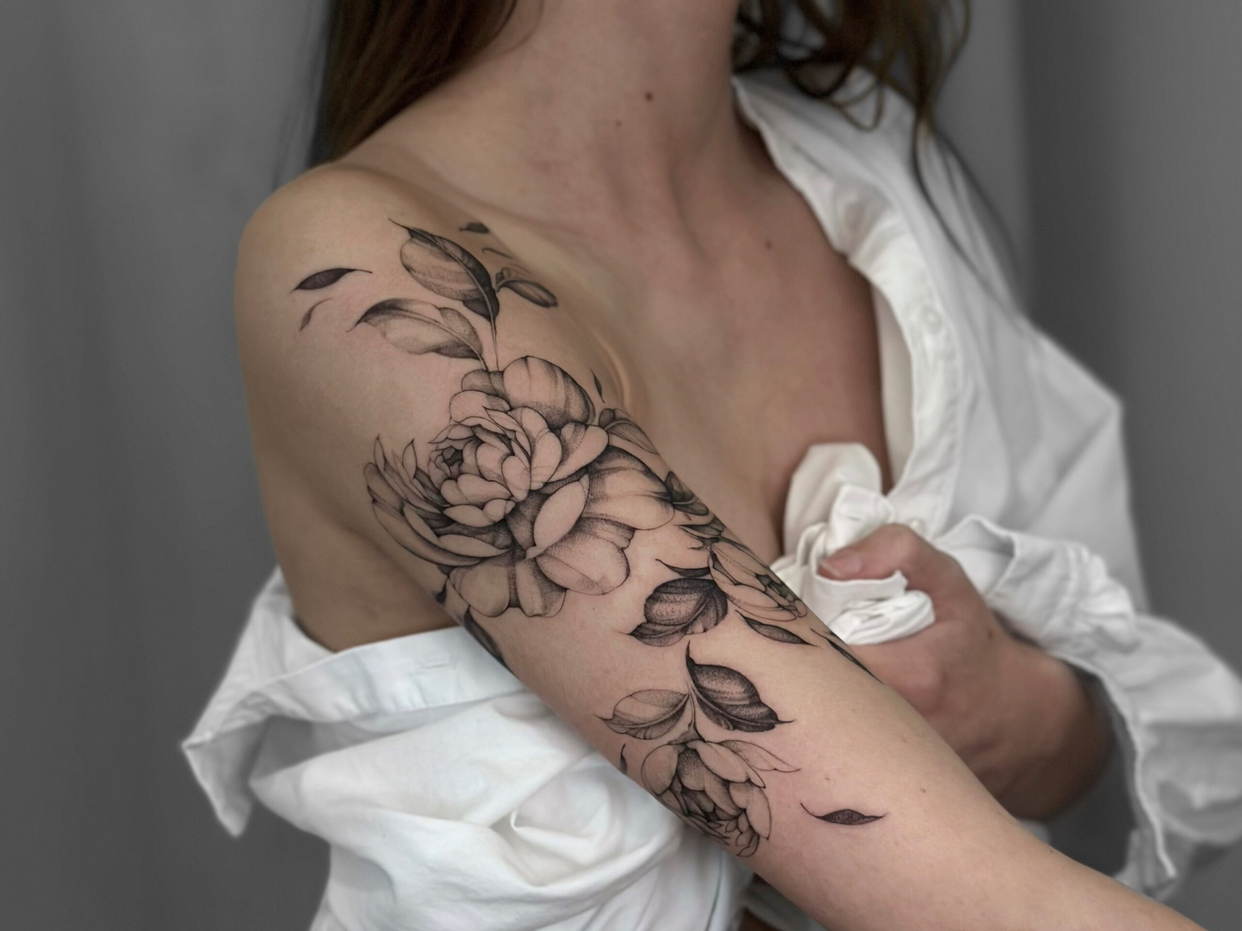 Großes florales fineline Tattoo an Schulter und Oberarm in Berlin