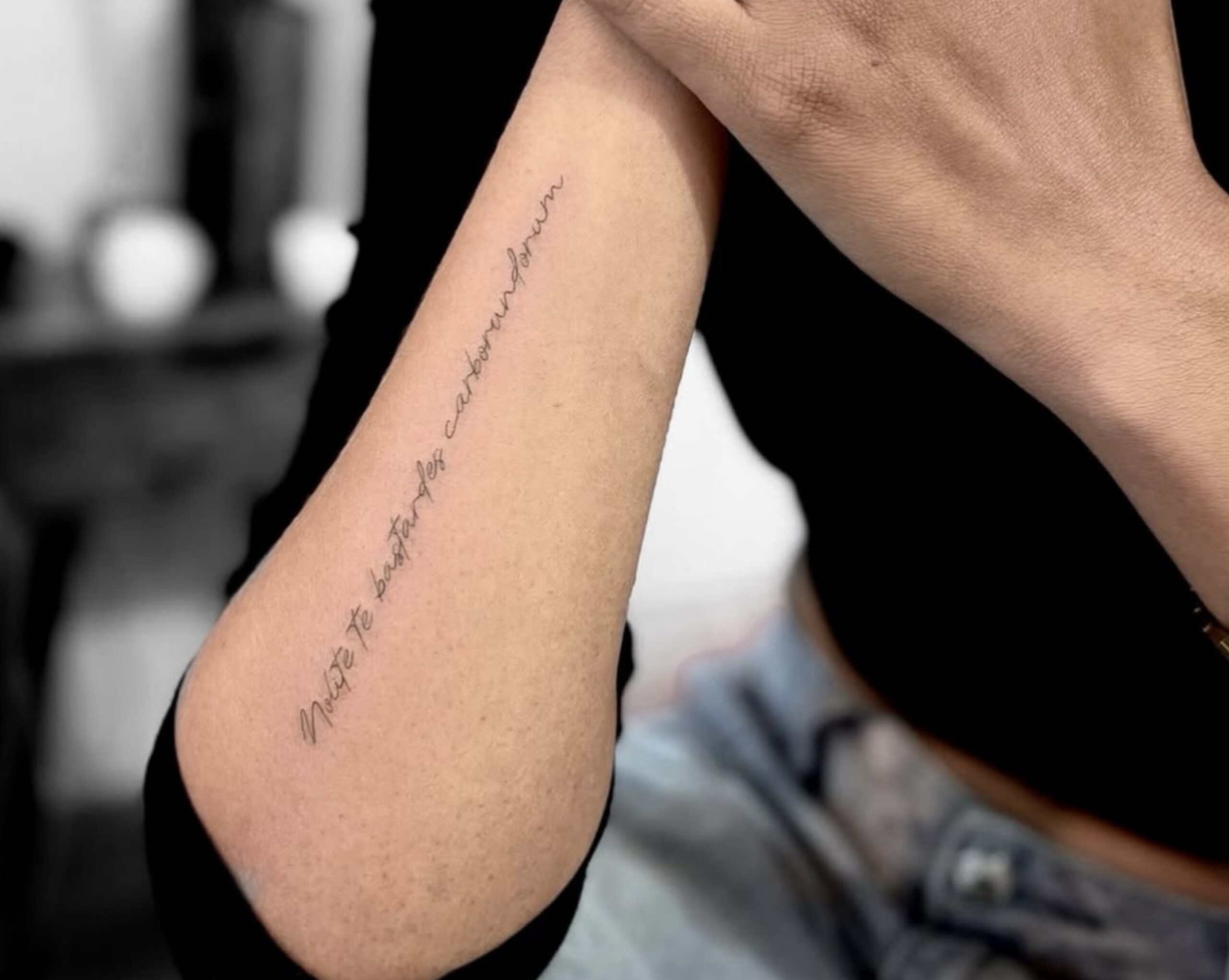 Fine Line Schriftzug-Tattoo am Unterarm in Berlin-Schöneberg