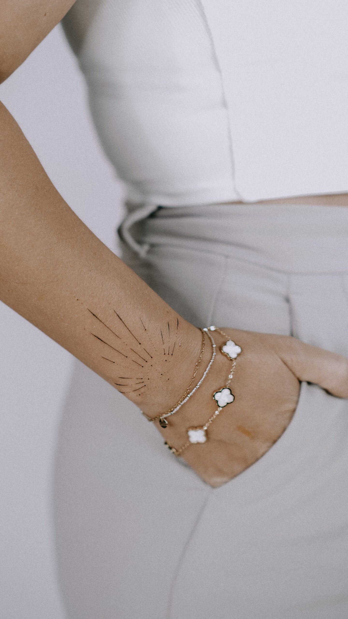 Fineline Sonnen-Tattoo mit Strahlen am Handgelenk in Berlin