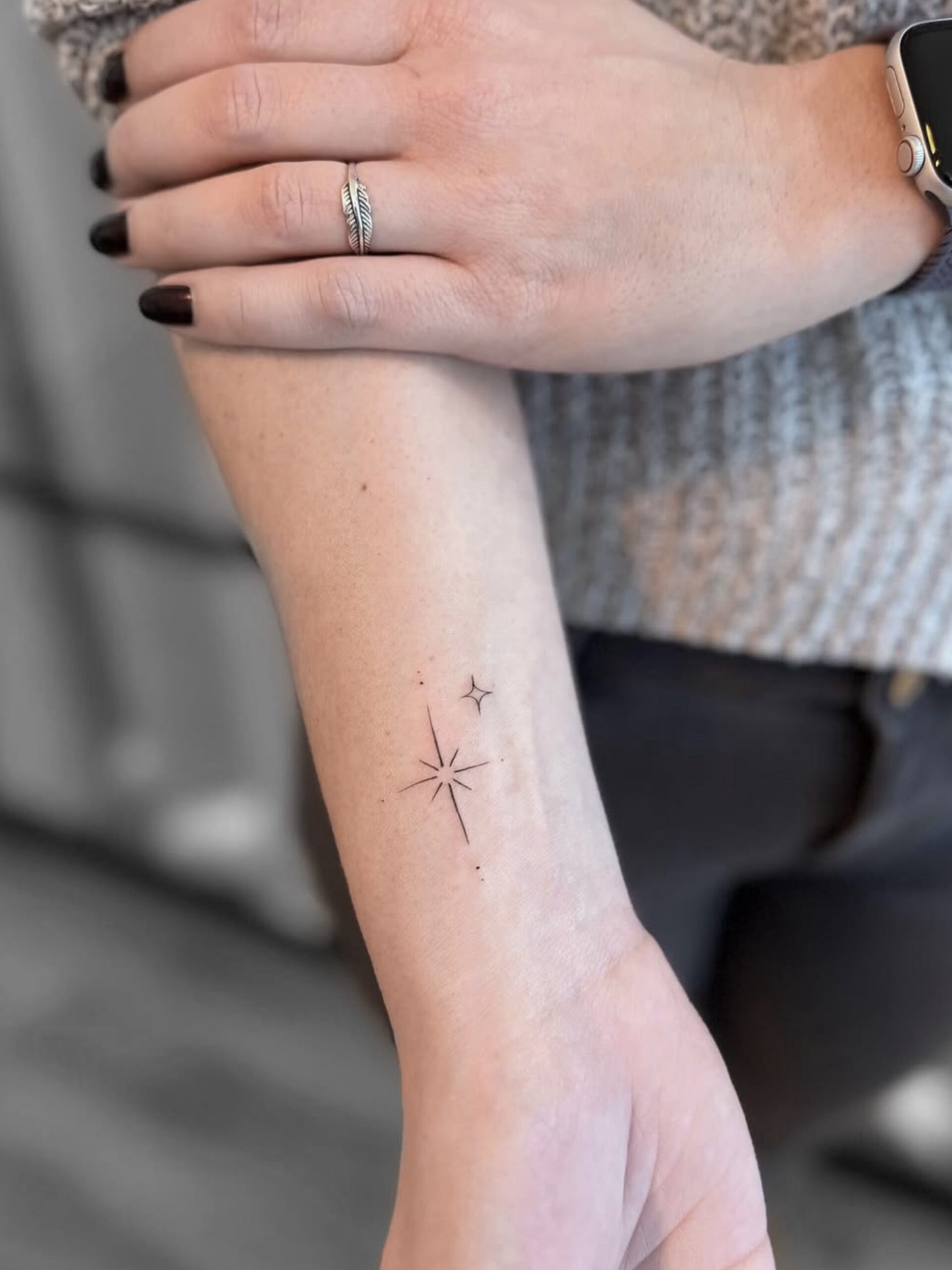 Fineline Stern-Tattoo mit Sonnenmotiv am Handgelenk in Berlin