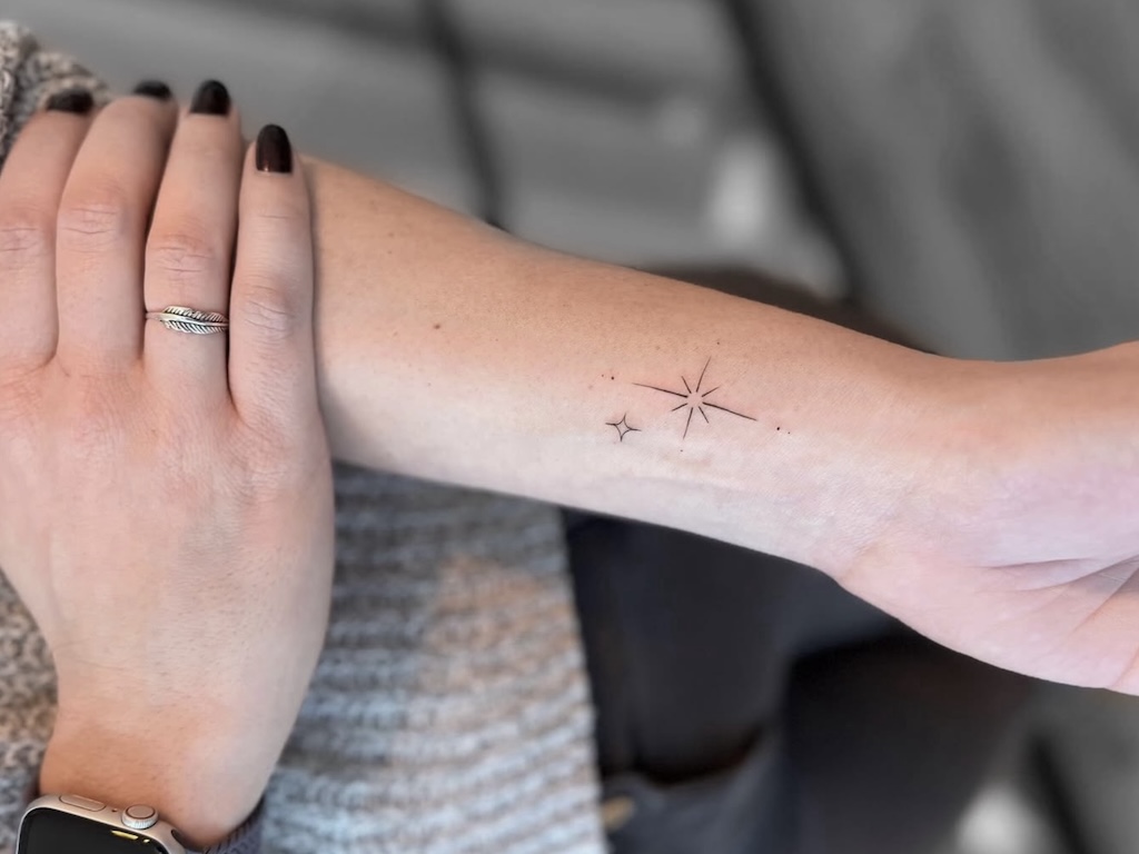 Fineline Stern-Tattoo mit Sonnenmotiv am Handgelenk in Berlin