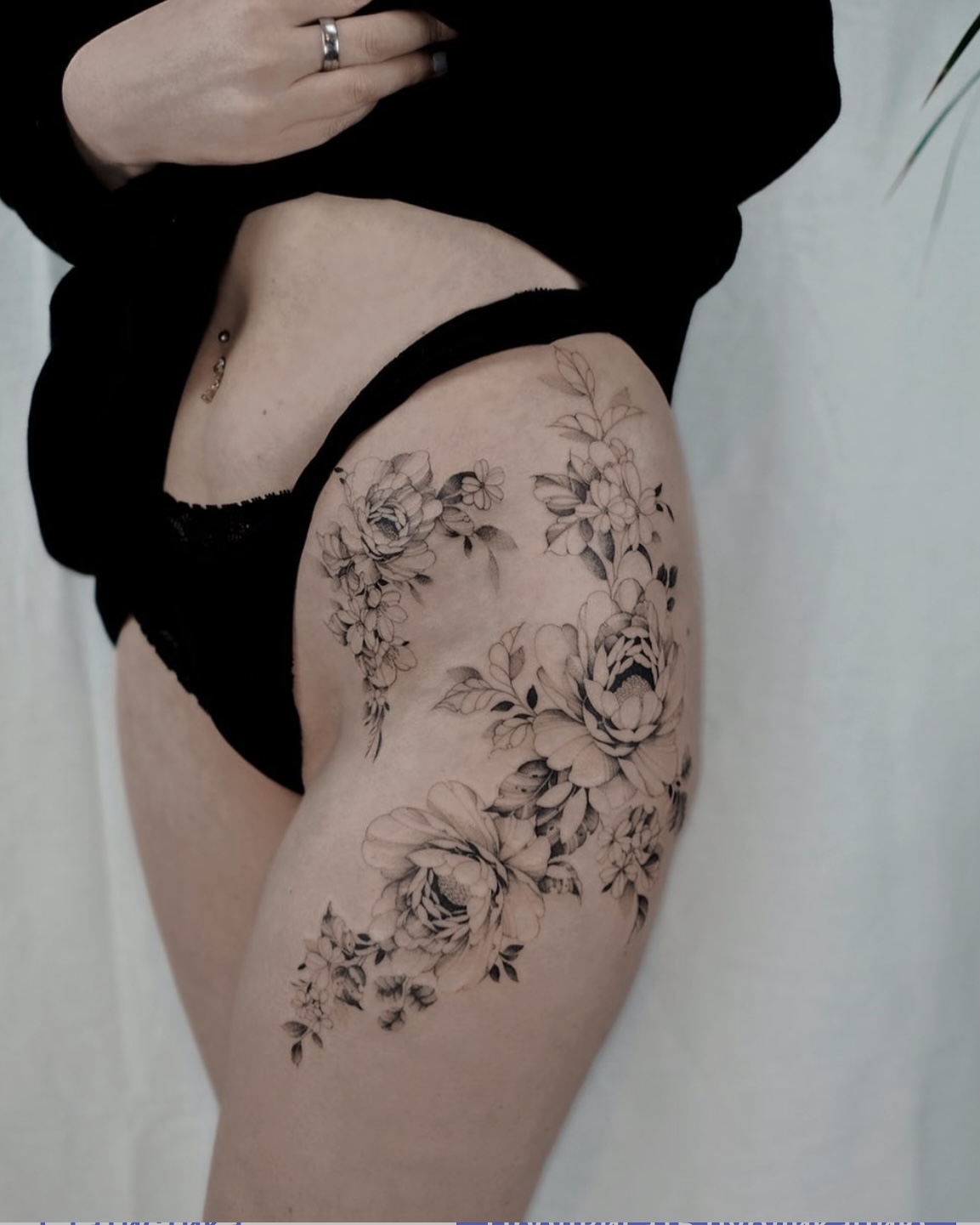 Großes florales Fine Line Tattoo an Hüfte und Oberschenkel in Berlin