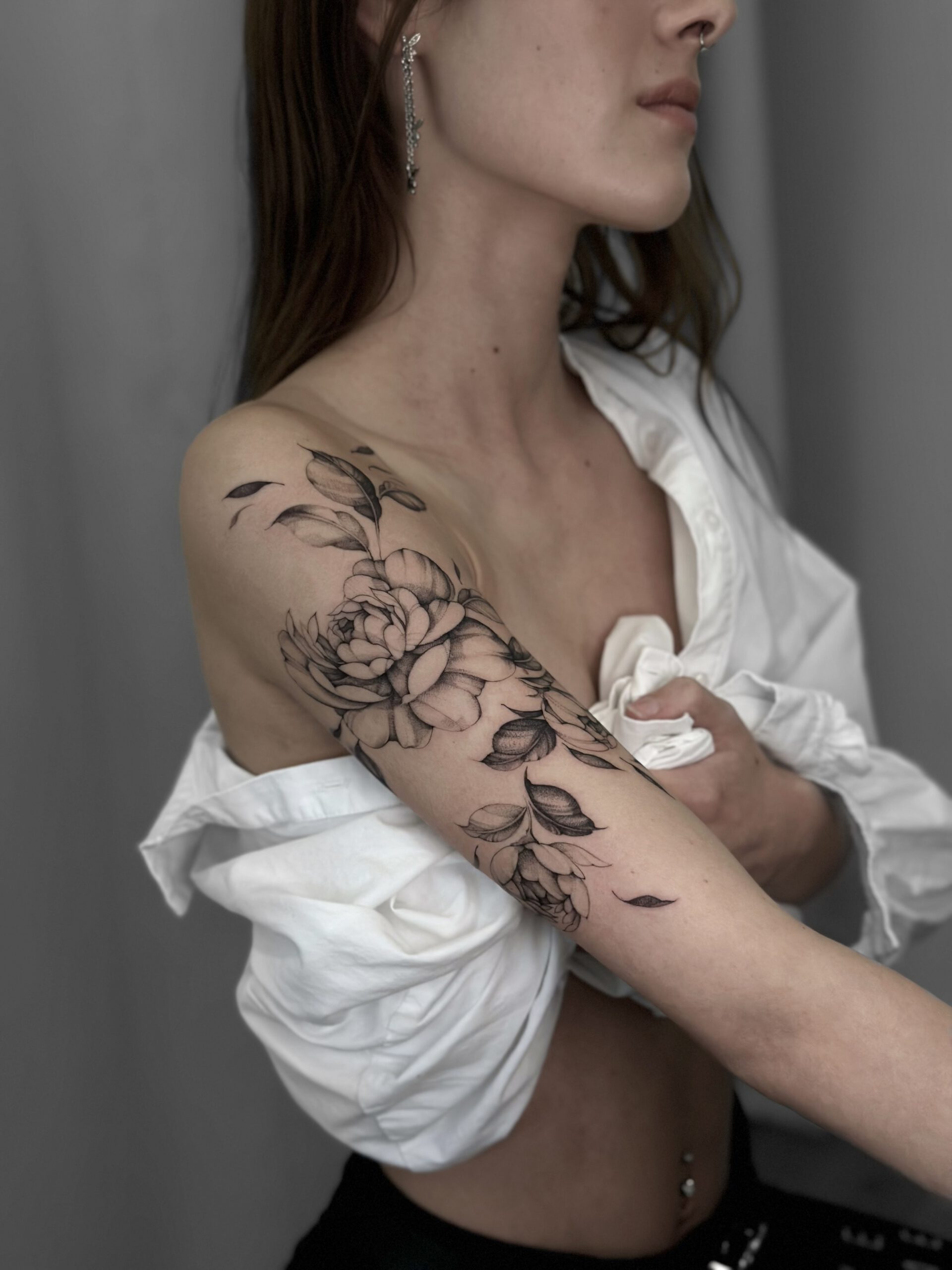 Großes florales Fineline Tattoo an Schulter und Oberarm in Berlin