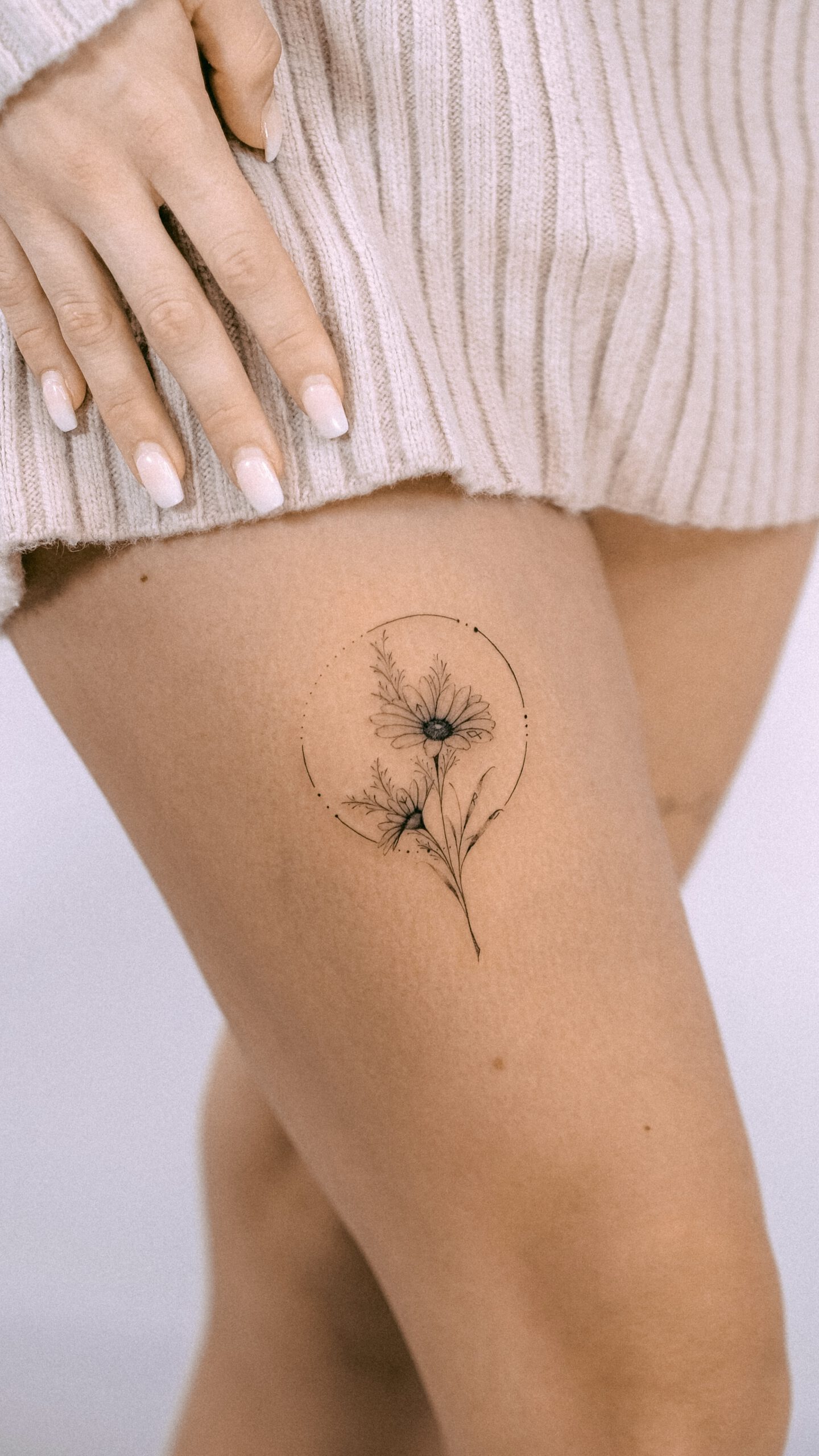 Kleines Fineline Blumen-Tattoo am Oberschenkel in Berlin-Schöneberg