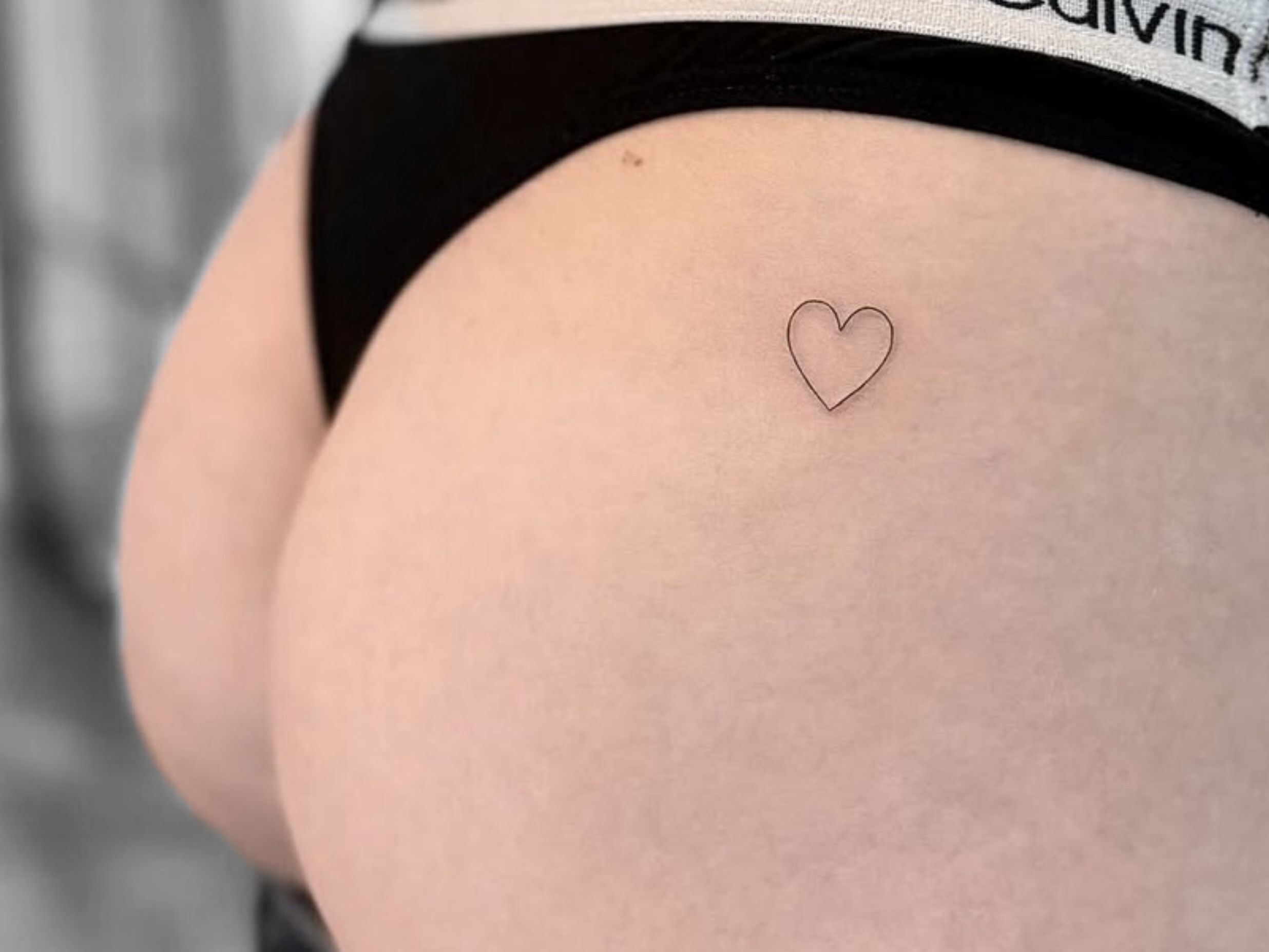Kleines minimalistisches Fineline Herz-Tattoo an der Hüfte in Berlin-Schöneberg