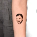 Hochpräzises Black and Grey Porträt Tattoo eines Kindes auf dem Handrücken, kreiert in unserem Schöneberg Tattoo Studio.