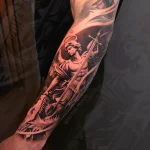 Detailliertes Black and Grey Unterarmtattoo mit einem Erzengel, Flügeln und Schwert