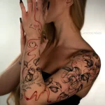 Filigranes florales Arm Tattoo mit Blumen, Blättern, Sternen und roten ornamentalen Linien