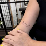 Filigranes Fineline Schriftzug Tattoo mit dem Spruch „dance now think later“ am Arm – minimalistisches Lettering Tattoo mit feiner Linienführung in Berlin.