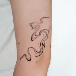 Zartes Fine Line Tattoo mit fließenden, abstrakten Wellenformen und kleinen Sternen am Unterarm, gestochen im Schöneberg Tattoo Studio.