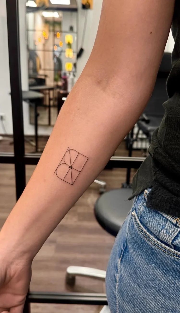 Präzises geometrisches Fine Line Tattoo mit rechteckigen Formen und zentralem Herz am Unterarm.