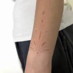 Zartes, geometrisches Fine Line Tattoo mit Sternen, Punkten und feinen Linien am Unterarm, gestochen in einem Berlin Tattoo Studio.