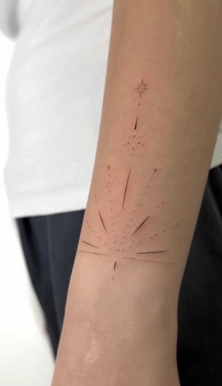 Zartes, geometrisches Fine Line Tattoo mit Sternen, Punkten und feinen Linien am Unterarm, gestochen in einem Berlin Tattoo Studio.