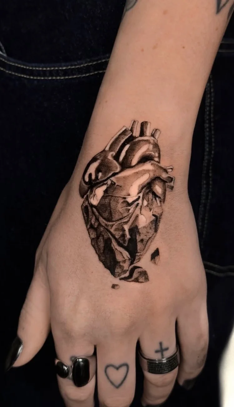 Ausdrucksstarkes, realistisches Black and Grey Tattoo eines anatomischen Herzens auf dem Handrücken, von BS Tattoo.