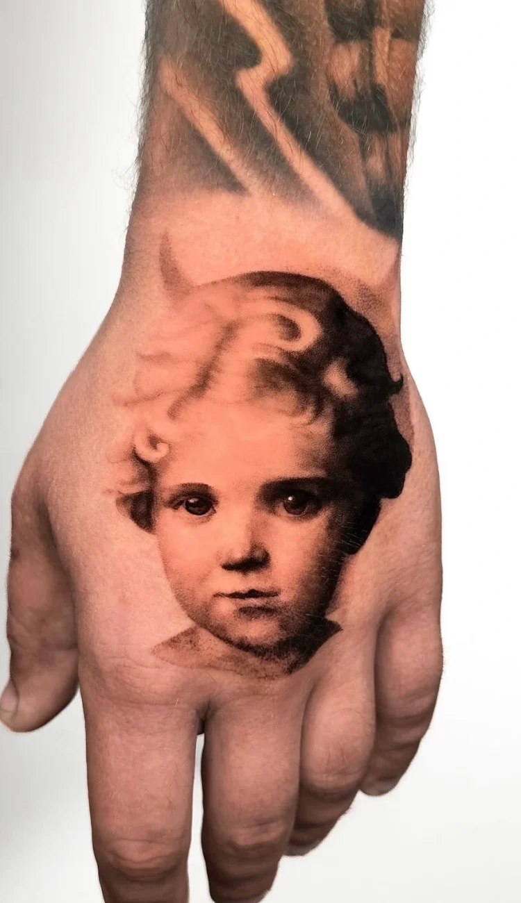 Feinstes Microrealismus Tattoo eines lachenden Babys auf dem Unterarm mit weichen Schattierungen, umgesetzt bei BS Tattoo.