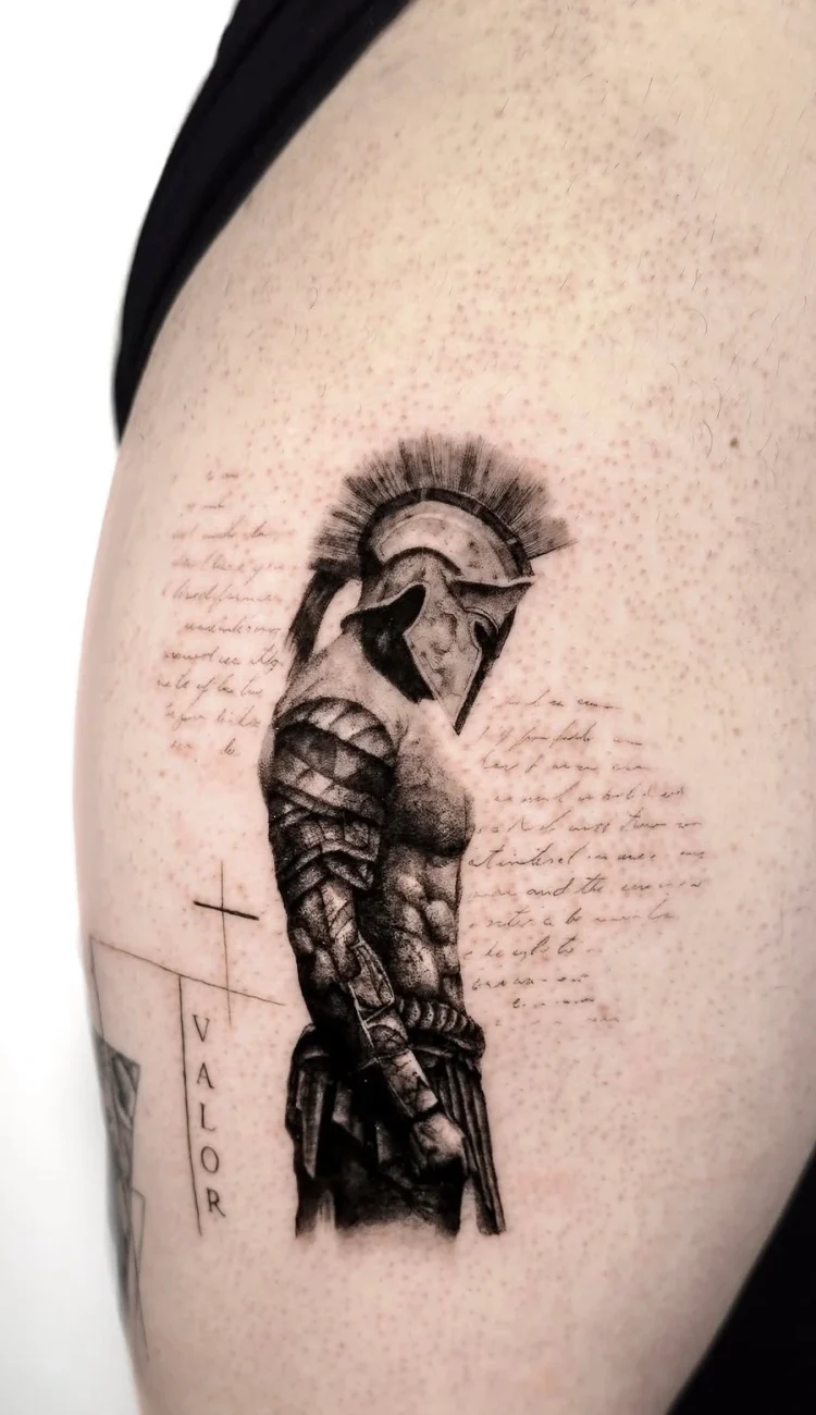 Detailliertes Black & Grey Microrealismus Tattoo eines spartanischen Kriegers mit Helm und Schriftzug auf dem Arm, gestochen von Black Smoke Tattoo Berlin.