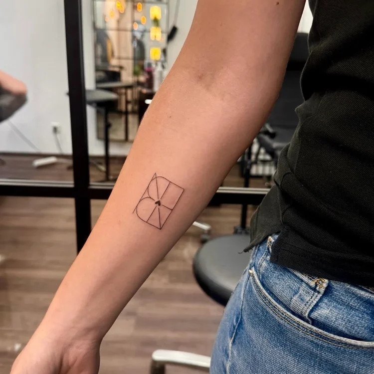 Präzises geometrisches Fine Line Tattoo mit rechteckigen Formen und zentralem Herz am Unterarm.